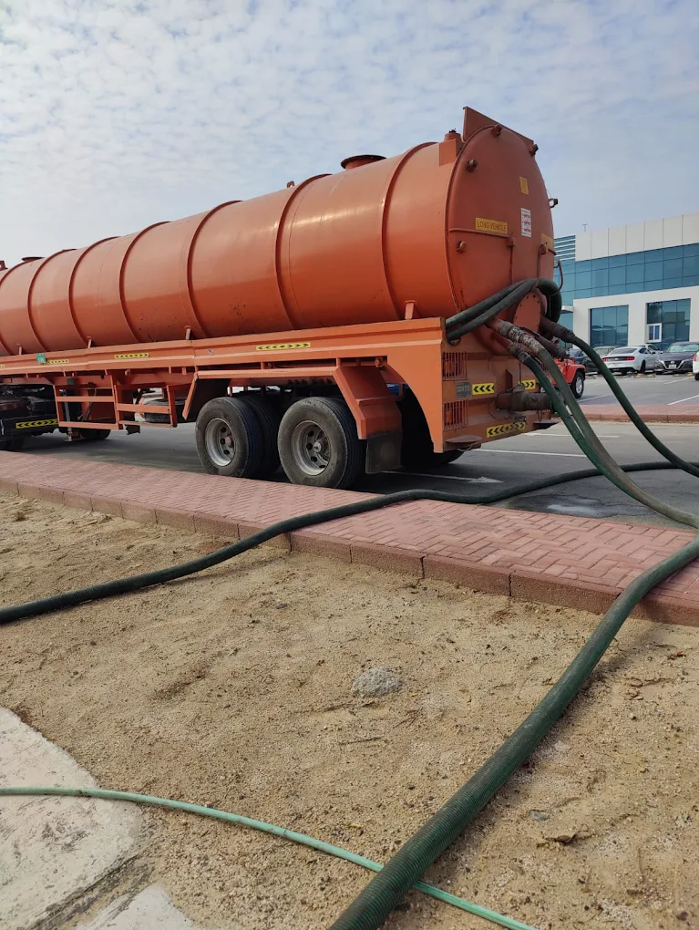 Orange high-capacity sewage vacuum tanker vehicle on site